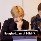 a man is laughing while sitting at a table with a tablet .
