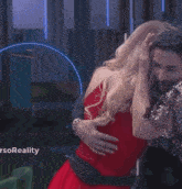 a woman in a red dress is dancing next to a man in a suit and tie .