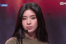a woman blowing a kiss in front of a sign that says katseye