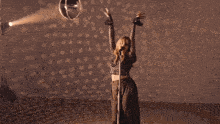 a woman is singing into a microphone and dancing .