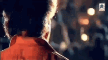 a close up of a person 's face in a dark room with a crowd in the background .