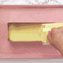yellow liquid is being poured into a pink pan
