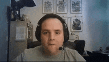 a man wearing headphones and a microphone is sitting in a room .