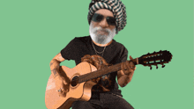 a man with a beard is playing a guitar with a green background