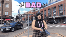 a woman in a plaid skirt is standing on a street with the word bad above her