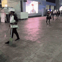 a man walking with a mop in his hand
