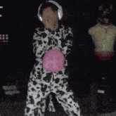 a person in a dalmatian costume holding a pink ball