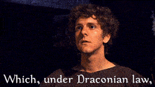 a man in a dark room with the words which under draconian law
