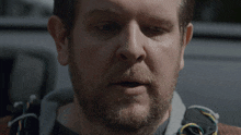 a close up of a man 's face with his eyes closed and a beard