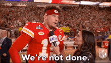 a man in a football uniform is being interviewed by a woman in a microphone .