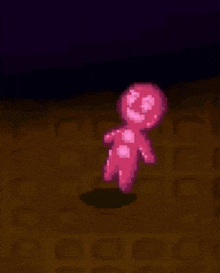 a pixel art of a pink gingerbread man standing on a brown floor .