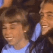 a group of people are sitting next to each other and smiling in a crowd .