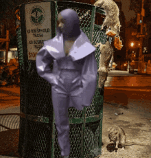 a woman in a purple suit is standing in front of a trash can that says no household trash