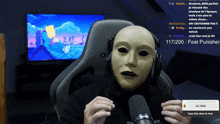 a man wearing a mask is holding a microphone in front of a screen that says 117/200 feat punisher
