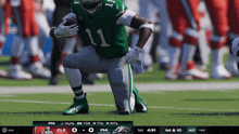 a football player with the number 11 on his jersey is kneeling on the field