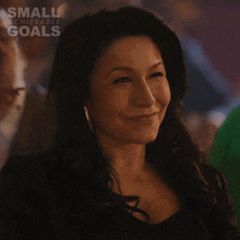a woman is smiling in a small achievable goals ad