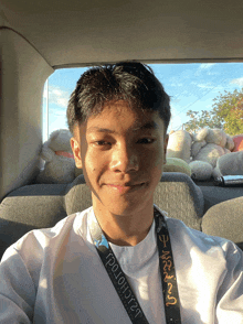 a young man in a car with a lanyard that says ' tp10h0rt ' on it