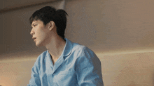 a man in a blue shirt is looking to the side