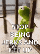 kermit the frog is sitting on a railing with the words `` stop being jerks and get up '' written on it .