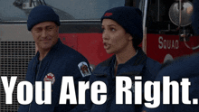 a man and a woman are standing in front of a squad truck