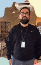a man with glasses and a beard wears a nike sweater