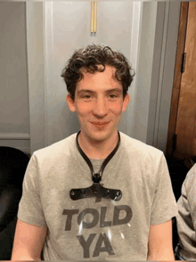 a young man wearing a gray shirt that says told ya