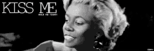 a black and white photo of a woman with the words kiss me