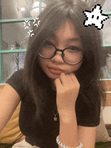 a girl wearing glasses and a black shirt has a pixel star on her head