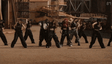 a group of women are dancing in front of a building with the letter s on it