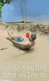 a man is laying on his back on a sandy beach with a bottle of water in his hand