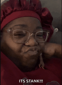 a woman wearing glasses and a red hat says it 's stank !!!