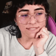 a woman with glasses and a nose ring is smiling