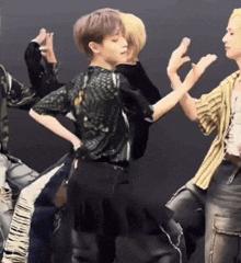 a group of people are standing next to each other on a stage and dancing .