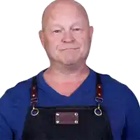 a man wearing a blue shirt and an apron that says mr. chef