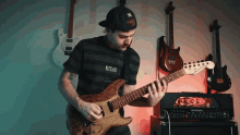 a man playing a guitar with a shirt that says wastelands on the front