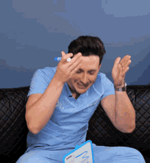 a man wearing a blue scrub top is holding a marker in his hand
