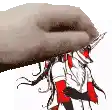 a hand is holding a drawing of a person in a red and white uniform .