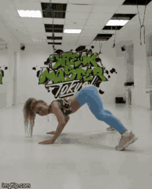 a girl is doing a handstand in front of a wall that has the word break on it