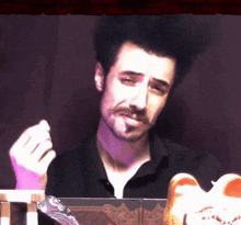 a man with a beard is smoking a cigarette while looking at something