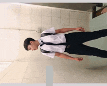 a man wearing a white shirt and black tie stands in a bathroom
