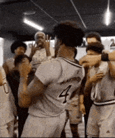 a basketball player with the number 4 on his back is surrounded by other players