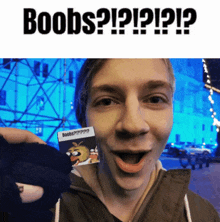 a man is holding a small card that says boobs