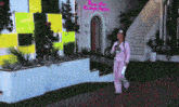 a woman in pink pajamas walks in front of a building with a sign that says ' pretty little liars ' on it