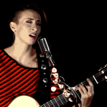 a close up of a person playing a guitar with their fingers on the strings