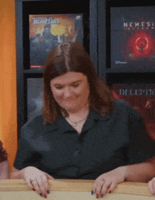 a woman sitting in front of a shelf with a book called nemesis