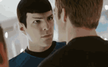 a couple of men are standing next to each other looking at each other .
