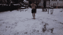 a man without a shirt is walking barefoot in the snow