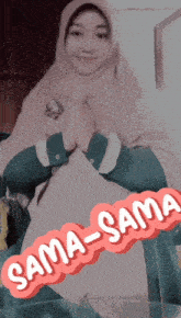 a woman in a hijab sits with her hands folded in front of a sign that says sama sama