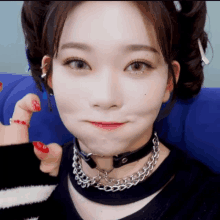 a close up of a woman wearing a choker and chains