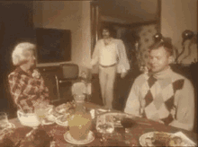 a group of people are sitting around a table with food
